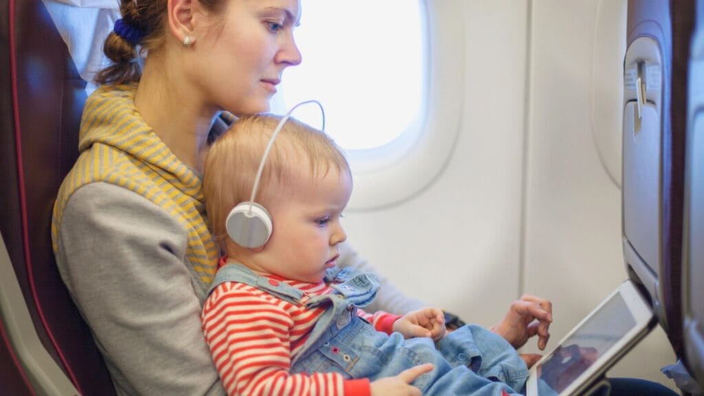 Mother and son using tablet on board of airplane