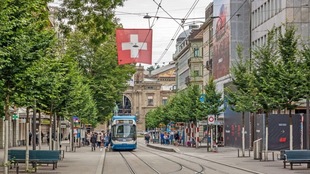 Zurich-shopping-street-Bahnhofstrasse-with-tram-and-swiss-flag