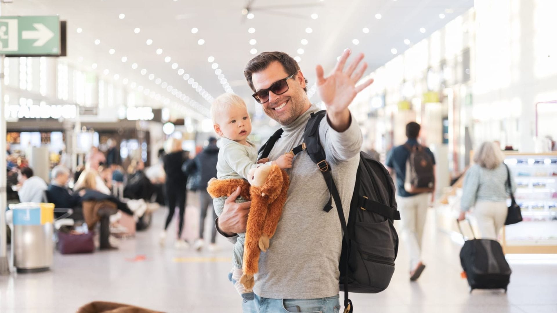 Father-traveling-with-child-holding-his-infant-baby-boy-at-airport